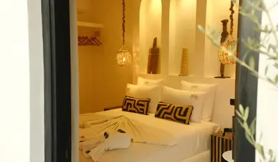 a bedroom with a bed with white sheets and pillows at Riad Dar Siyah in Marrakech