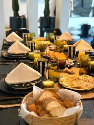 a table with a basket of bread and plates of food at Riad Dar Siyah in Marrakech
