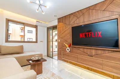a living room with a television on a wall at Elegant Guéliz Apartment in Marrakech