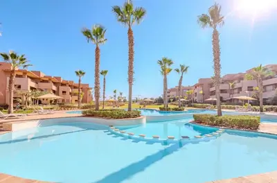 a swimming pool at a resort with palm trees at Luxury 3BD Golf View Pool Fast Fiber WiFi in Marrakech