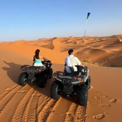 a man and woman riding atvs in the desert at Yassen luxury camp in Marrakech