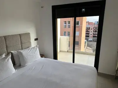 a bedroom with a white bed and a large window at Nour in Marrakech