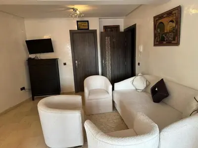 a living room with two white chairs and a couch at Nour in Marrakech