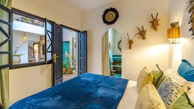 a bedroom with a blue comforter on a bed at Riad Awajana Marrakech - Piscine - Jacuzzi in Marrakech