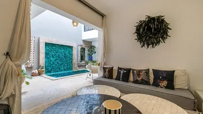 a living room with a couch and a table at Riad Awajana Marrakech - Piscine - Jacuzzi in Marrakech