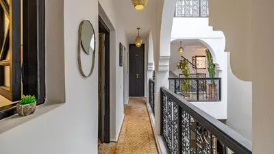 a hallway of a home with a staircase and a mirror at Riad Awajana Marrakech - Piscine - Jacuzzi in Marrakech