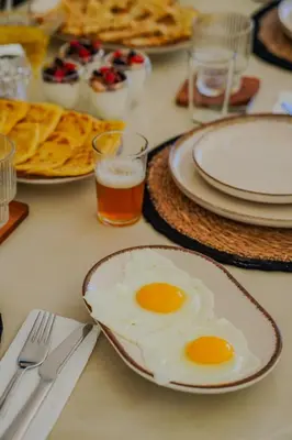 two fried eggs on a table with glasses of beer at MIKESTAY - Villa Sherazade in Marrakech