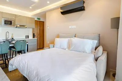 a bedroom with a large white bed and a kitchen at Marrakesh, Noria Residence, Luxury 1BR, Atlas View in Marrakech