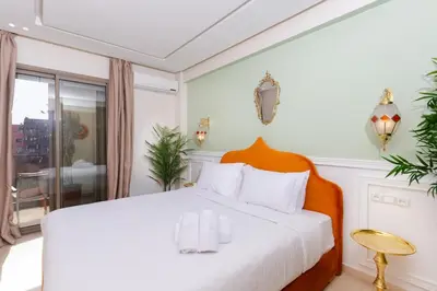 a white bedroom with a large bed and a window at Lalla Homes 369 in Marrakech