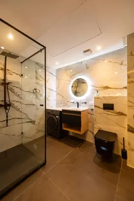 a bathroom with a shower and a sink and a mirror at Exceptional Apartment Overlooking Marrakech Train Station in Marrakech