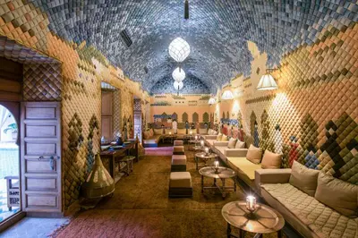 a lobby with couches and tables and a wall of tiles at Almaha Marrakech Restaurant & SPA in Marrakech