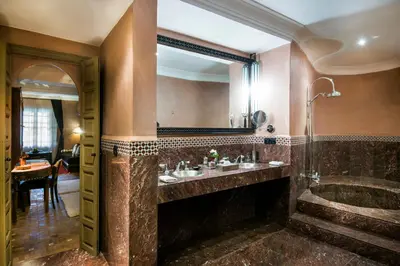 a bathroom with a tub and a sink and a mirror at Almaha Marrakech Restaurant & SPA in Marrakech