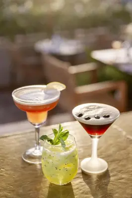 two cocktails sitting on a table with a drink at Almaha Marrakech Restaurant & SPA in Marrakech