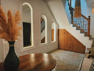 a living room with a table and a staircase at Kasbah Djellaba pool breakfast city center in Marrakech