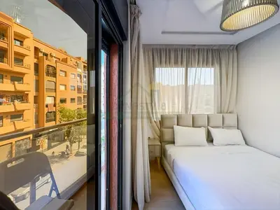 a bedroom with a white bed and a window at Appartement de charme au cœur de la ville rouge in Marrakech