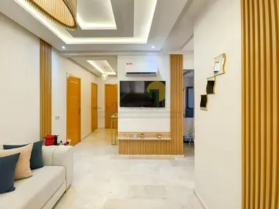 a living room with a couch and a flat screen tv at Appartement de charme au cœur de la ville rouge in Marrakech