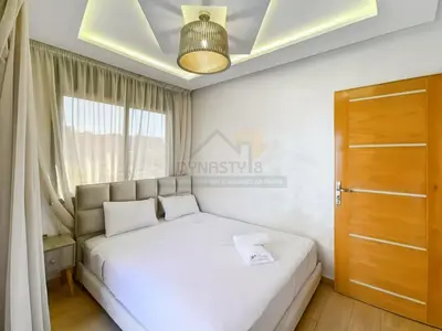a bedroom with a white bed and a window at Appartement de charme au cœur de la ville rouge in Marrakech