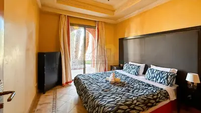 a bedroom with a bed and a large window at Evasion élégante à la Palmeraie in Marrakech