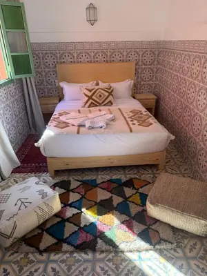 a bedroom with a bed with a colorful rug at Riad R Art in Marrakech