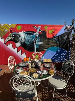 a table with food on it in front of a mural at Riad R Art in Marrakech