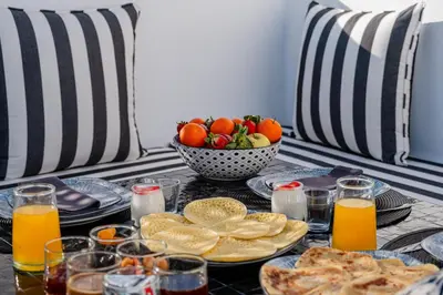 a table with plates of food and a bowl of fruit at Riad Alaya in Marrakech