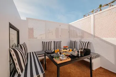 a small balcony with a table and chairs at Riad Alaya in Marrakech