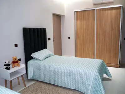 a bedroom with a bed and a cabinet and a teddy bear at HU Aappartement in Marrakech