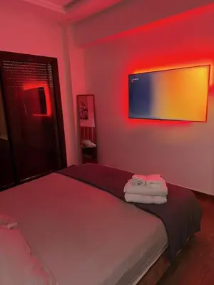 a bedroom with a bed with red lights on the wall at Luxury 2-room apartment - Pool view in Marrakech