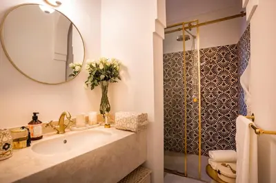 a bathroom with a sink and a mirror and a shower at Riad Anaqa in Marrakech