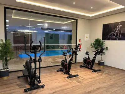 a gym with treadmills and exercise bikes in a room at Appartement Haut standing Gueliz, Piscines, jacuzzi chauffé & Fitness in Marrakech