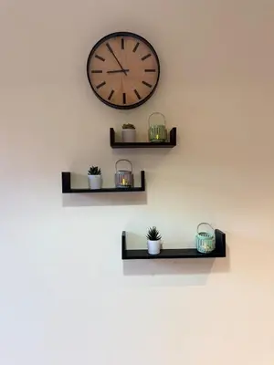 a clock on a wall with some plants on it at Appartement Haut standing Gueliz, Piscines, jacuzzi chauffé & Fitness in Marrakech