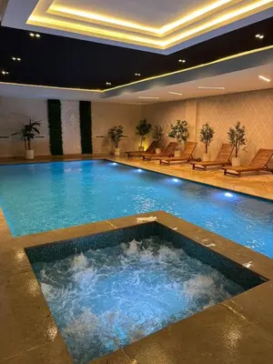 a large swimming pool in a hotel with chairs at Appartement Haut standing Gueliz, Piscines, jacuzzi chauffé & Fitness in Marrakech
