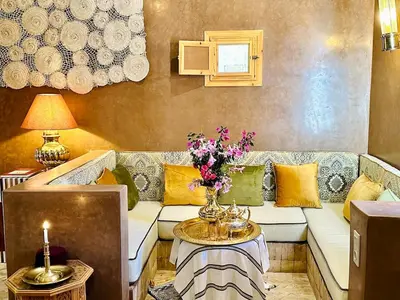 a living room with a couch and a table with flowers at Villa Romana in Marrakech