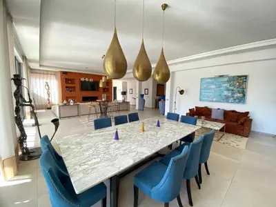 a dining room with a large table and blue chairs at Villa Ines Piscine chauffée & Jacuzzi & Hammam in Marrakech