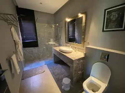 a bathroom with a toilet and a sink and a mirror at Villa Ines Piscine chauffée & Jacuzzi & Hammam in Marrakech