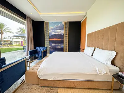 a bedroom with a large bed and a large window at Private Mountain View Oasis in Bou Azza