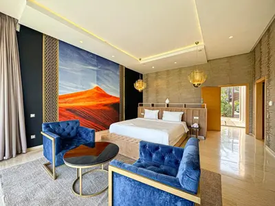 a bedroom with a bed and a couch and a table at Private Mountain View Oasis in Bou Azza