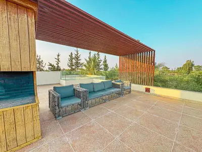 a patio with a couch and chairs on a patio at Private Mountain View Oasis in Bou Azza