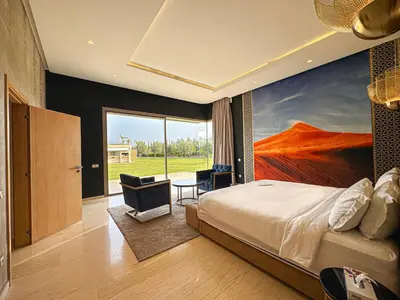 a bedroom with a bed and a painting on the wall at Private Mountain View Oasis in Bou Azza
