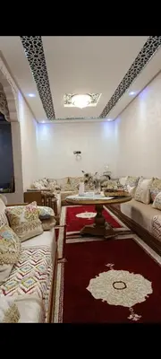 a room with couches and a table and a red rug at Afaq1,saada in Marrakech