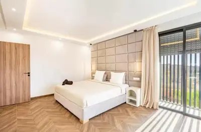 a bedroom with a white bed and a large window at Kais in El Rhechat