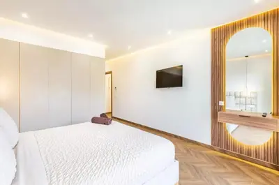 a bedroom with a white bed and a mirror at Kais in El Rhechat