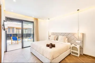 a bedroom with a large bed and a balcony at Kais in El Rhechat