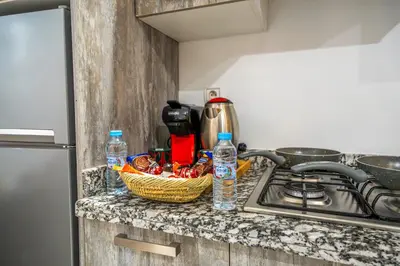 a kitchen counter with a basket of food and water bottles at The best JINANE in Marrakech