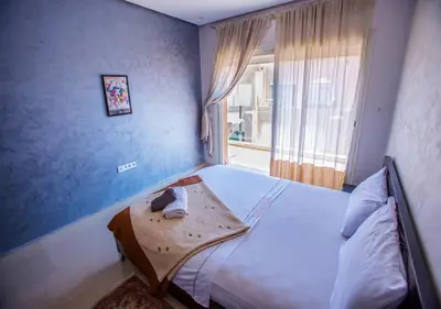 a bedroom with a large bed with a window at Le Chic Urbain Tout à Pied Clim Design Chic in Marrakech