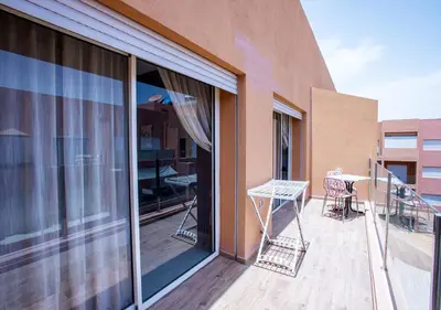 a balcony with a table and chairs on a building at Le Chic Urbain Tout à Pied Clim Design Chic in Marrakech