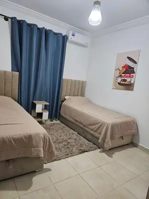 a bedroom with two beds and a blue curtain at Chya home in Marrakech