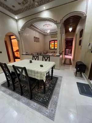 a dining room with a table and chairs and a kitchen at Appartement familial Marrakech in Marrakech
