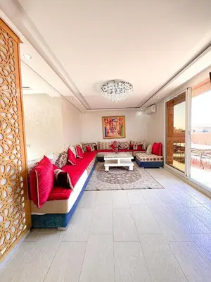 a living room with a red couch and a table at Appartement de luxe Marrakech - Targa in Marrakech