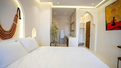 a bedroom with a white bed and a bathroom at Majorelle Garden - Design apartment in Marrakech